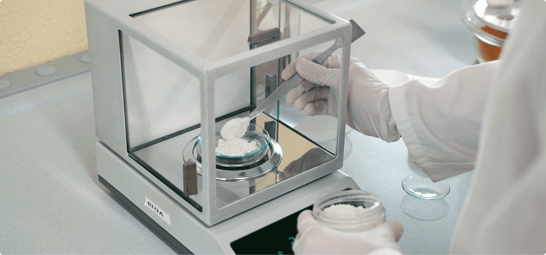 Scientist weighing white powder on a laboratory scale